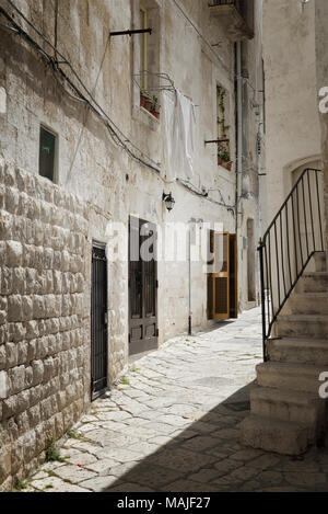 Wäscheservice Tag in Italien mit weißen Decken hängen von einem Haus aus Stein in einem gepflasterten Gasse in einem alten italienischen Stadt zu trocknen. Stockfoto