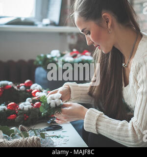 Schöne Frau, die Weihnachtsdekoration zu Hause Stockfoto