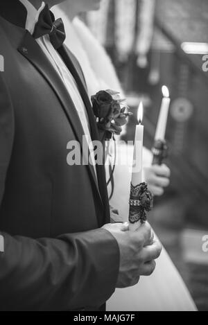 Trauung in der Kirche, junges Ehepaar holding Kerzen, christliche Traditionen Stockfoto