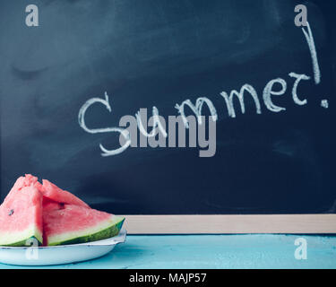 Sommer auf der Tafel mit Scheiben Wassermelone auf blauem Hintergrund geschrieben. Sommer Konzept. Stockfoto