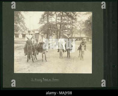 Horizontale, sepia Foto zeigt zwei Jungs, zwei Männer und eine Frau Reiten Esel. Sie haben für den Fotografen und alle lächeln in die Kamera angehalten. Titel: 'Im Bergbau Gulch auf Eseln" (Weltweit 1904 Fair). . 1904. Stockfoto