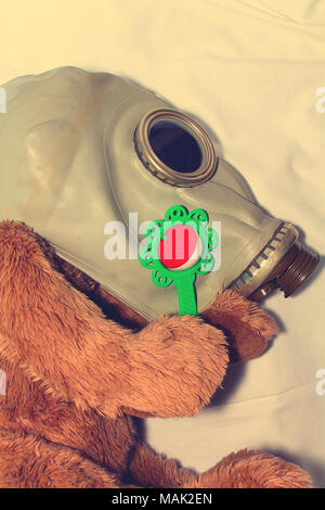 Ein Spielzeug in einer Gasmaske als ein Konzept für den Schutz der Kinder, die sich aus der Verwendung von Gas Waffen, Umweltverschmutzung und der Internationale Tag des Gedenkens Stockfoto