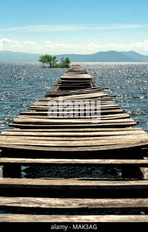 Eine alte wonky und gebrochene Anlegestelle Anlegestelle zu Mangroven jetten, Nordsee Insel Sumbawa, Indonesien. Stockfoto