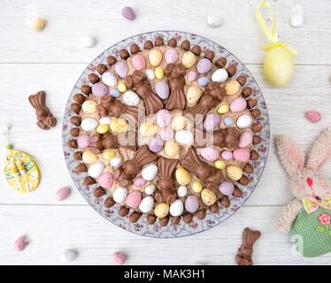 Auf der Suche nach unten von oben auf ein Ostern Feier Kuchen in mini Ostereier und Schokolade Süßigkeiten auf weißem Hintergrund Stockfoto