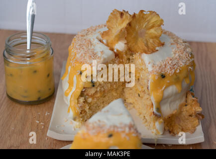 In Scheiben geschnittene Ananas und Kokosnuss Layer Cake mit Passionsfrucht Sauce. Mit Ananas Blumen geschmückt. Stockfoto