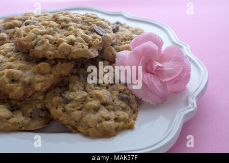 Chocolate Chip Cookies für Mutter auf rosa Hintergrund dekoriert mit rosa Blume Stockfoto