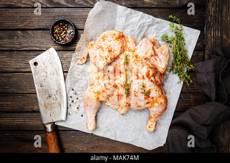 Organische Rohstoffe ganzes Huhn gebeizt mit Gewürzen auf Holz rustikale Hintergrund Stockfoto