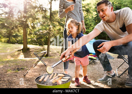 Familie camping im Wald, Kochen von Fleisch auf Grill. Stockfoto