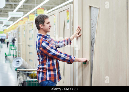 Man wählt eine Holztür in einem Gebäude lagern Stockfoto