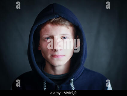Ein hübscher Kerl in einem blauen hoodie mit einer Haube auf dem Kopf. Stockfoto