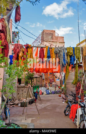 Marokko Marrakesch Djemaa el Fna MEDINA SOUK HOF mit bunt gefärbte Wolle und orange Blätter aus hängenden Stangen ZUM TROCKNEN IN DER SONNE Stockfoto