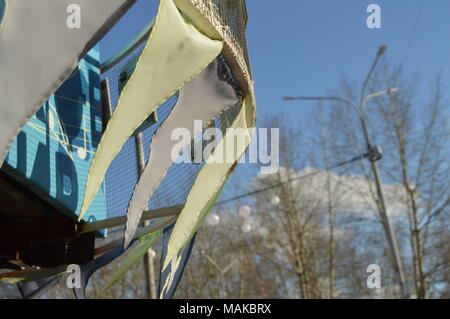 Close-up, selektiver Fokus, Wind klatscht Girlanden aus bunten Fahnen gegen den blauen Himmel, Park im Frühling Stockfoto