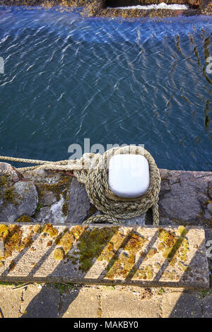 Poller und Seil auf einem Stein Kai bei Douglas Hafen, Insel Man Stockfoto