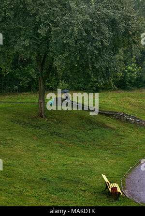 Starker Regen in der lokalen Park, zwei Menschen zu Fuß unter einem Dach fernen Stockfoto