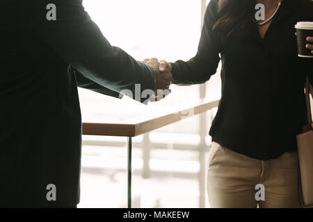 In der Nähe von Mann und Frau die Hände schütteln im Amt. Kollegen handshaking und Begrüßung. Stockfoto