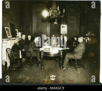 Horizontale, sepia Foto, acht Männer und eine Frau an einem Tisch sitzt. Es gibt einen Kamin auf der Linken, einen Spucknapf in der Mitte vorne, ein Kronleuchter in der Mitte Overhead, ein Kalender mit Dezember 1911 Auf der Rückseite der Wand, und einen vollen Schreibtisch auf der linken Seite. Nach rechts: E.V. Papin, W.B. Links Stevens, Charles S. Pettus (Sekretärin), D.I. Bushnell, W.K. Bixby (Präsident), Breckenridge Jones (Schatzmeister), Walter B. Douglas (Vizepräsident), Idress Kopf (Bibliothekar), Robert McCulloch Titel: Missouri Historical Society Kuratorium. . Dezember 1911. Stockfoto