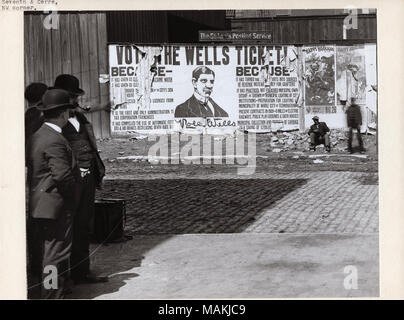 Horizontal, Schwarz und Weiß Foto, ein politisches Plakat für Rolla Wells während seiner Kampagne für die Bürgermeister von St. Louis. Das Plakat war an der nordwestlichen Ecke der 7th und Cerre Straßen. Es beschreibt die Politik unter der ersten Wells' Begriff umgesetzt als Bürgermeister, und das Poster ist zerrissen und an mehreren Stellen zerrissen. Mehrere Männer stehen auf der Straße Ecke entlang der linken Kante des Fotos, und ein anderer Mann sitzt auf einem Felsvorsprung unterhalb der Anschlagtafel. Werbung für Happy Hooligans theater Produktionen können auf der rechten Seite gesehen werden. Rolla Brunnen diente als St. Louis?s Bürgermeister fr Stockfoto