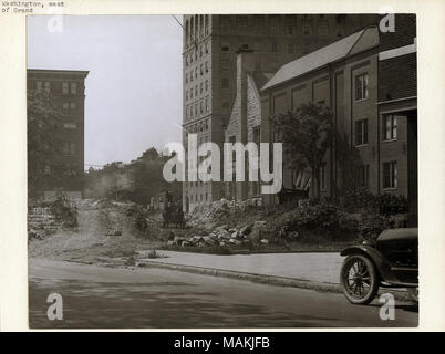 Horizontal, Schwarz und Weiß Foto, Bauarbeiten auf der Washington Avenue cut-off, östlich von Grand Avenue. Teil einer niedrigen Mauer aus Stein an der Grenze zu den Bürgersteig auf der Washington Avenue wurde abgerissen worden. Ein Mann stand auf einem Wagen gesehen Schaufeln ein Haufen Schmutz hinter der Wand. Washington Avenue verläuft im Vordergrund, und mehrere Stein und Ziegel können Gebäude im Hintergrund gesehen werden. Das vordere Ende einer geparkten Auto kann an der rechten Seite gesehen werden. Titel: Arbeiter beim Bau der Washington Avenue cut-off, östlich von Grand Avenue. . 1916. Holt, Charles Cleme Stockfoto
