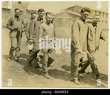 Horizontale, sepia Foto, eine Gruppe von sieben Männer, einige mit Uniformen und einige in ziviler Kleidung, entlang einem Feldweg Holding mess Kits und Tassen. Holz können Gebäude im Hintergrund des Bildes zu sehen. Auf der Rückseite des Fotos ist das Schreiben, das liest: "C.V.S. Michel = Foto/St. Louis Stern." Titel: Sieben Männer Hinunter eine Dirt Road Holding Mess Kits und Tassen. . Zwischen ca. 1914 und ca. 1918. Michel, Carl Stockfoto