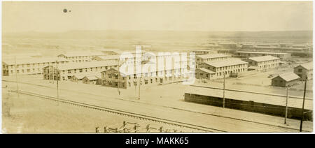 Horizontale, sepia Foto zeigt einen Blick auf einer großen Gruppe von Lange zweistöckige Gebäude, evtl. Kasernen, die durch Stromleitungen und Gleise begrenzt. Das Foto erscheint aus einem Hügel oder einigen anderen hohen Boden am Rande der Gebäude genommen worden zu sein. Titel: Blick auf die große Gruppe von Gebäuden, Kasernen, aus einem Gebiet des hohen Bodens berücksichtigt. . Zwischen ca. 1914 und ca. 1918. Michel, Carl Stockfoto