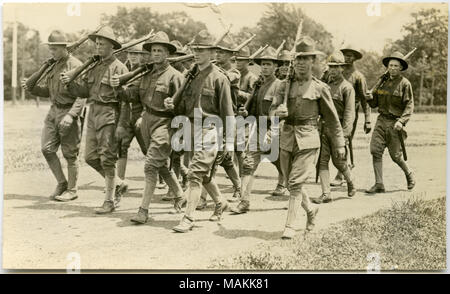 Horizontale, sepia Foto zeigt eine Gruppe von uniformierten Soldaten marschieren entlang einer Schmutz weg, während sie Gewehre. Titel: Gruppe von Soldaten marschieren auf einem unbefestigten Weg durch eine Rasenfläche. . Zwischen ca. 1914 und ca. 1918. Michel, Carl Stockfoto