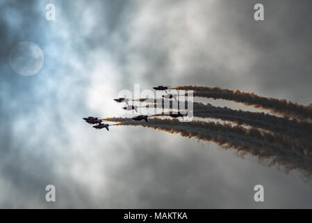 Die RAF Aerobatic Display Team, die roten Pfeile, aus der Dunkelheit und fliegen in Richtung zur Sonne und blauen Himmel bei yeovilton Air Tag, UK auf 8/7/17. Stockfoto