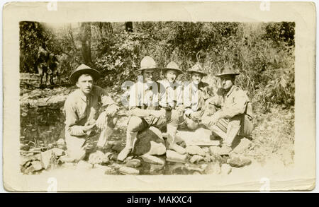 Horizontale, sepia Foto, fünf uniformierte Soldaten sitzen auf dem Boden oder auf Felsen in einem stark bewaldeten Gebiet. Die Soldaten sind posieren für ein Gruppenfoto. Titel: Fünf Soldaten für eine Gruppe Bild in einem stark bewaldeten Gebiet posieren. . Zwischen ca. 1916 und ca. 1918. Stockfoto