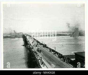 Horizontal, schwarz-weiß Foto zeigt die Eads Brücke bei Hochwasser im Jahr 1892. Fußgänger sind entlang der Geländer auf beiden Seiten der Brücke voll, Peering über die Kante am Mississippi Fluss unten. Mehrere Wagen und Kutschen fahren Sie auf der Mitte der Brücke. Titel: Fußgänger Futter Eads Bridge während der Flut, Mai 1892. . Mai 1892. Stockfoto