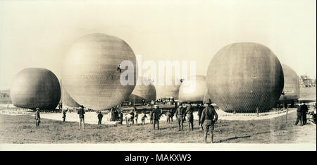 Horizontale, schwarze und weiße Panorama Foto, mehrere Heißluftballons fast vollständige Inflation. Es ist ein Goodyear Ballon ist im Vordergrund mit einem Mann die Skalierung der Seite. Titel: Heißluftballons teilweise an ein Feld aufgeblasen im Süden von St. Louis. . 1919. Personen, W.C. Stockfoto