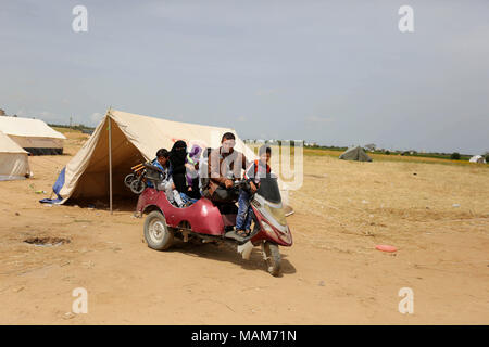 Khan Yunis, Gazastreifen, palästinensischen Gebiet. 3 Apr, 2018. Palästinensischen Fadi Abu Salah, der seine Beine in 2008 nach Israels Angriff in Gaza reitet sein Motorrad neben Zelte mit seiner Familie in einem Zelt Stadt Protest an der Israel-Gaza Grenze beteiligen, in Khan Yunis im südlichen Gazastreifen, auf den 3. April 2018 Credit: Ashraf Amra/APA-Images/ZUMA Draht/Alamy Leben Nachrichten verloren Stockfoto