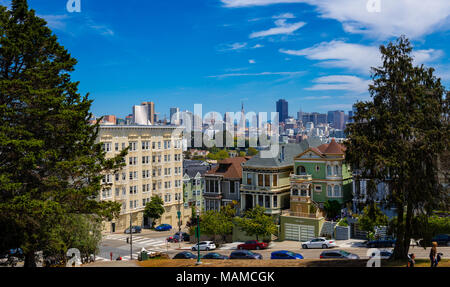 San Francisco, CA: Die Painted Ladies in der Steiner Straße mit Blick auf Alamo Square und die moderne Skyline der Stadt. Stockfoto