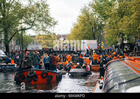 Amsterdam, Niederlande - 27 April 2017: Stau aus Boote im Kanal. Einheimische und Touristen in orange gekleidet Fahrt auf Boote und Teilnehmer Stockfoto