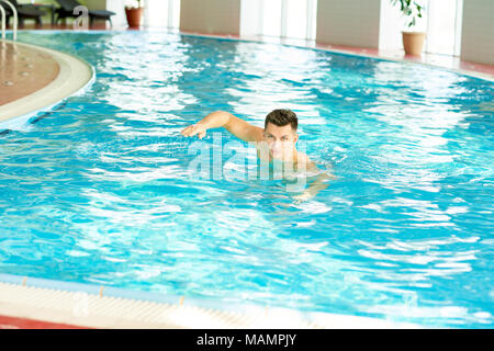 Junger Mann, Schwimmen im Pool Stockfoto