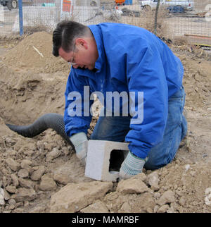 Künstliche Eule Burrows-Las Las Vegas, NV. Bob Wilkin, Präsident der Red Rock Audubon Society, bereitet eine Höhle Eingang. Stockfoto