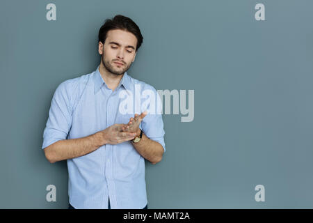 Schöne nachdenkliche Mensch seine Hand berühren. Stockfoto