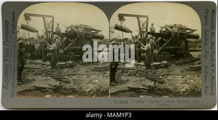 Horizontale, Sepia stereocard angezeigt uniformierte Männer, die eine Munition Shell aus dem Boden in der Vorbereitung für das Laden in ein großes Geschütz Kanone. Keystone Stereograph Anzahl V 18911. Der Titel lautet: 'Einzug' Street Fighter"-Shell Gehisst in Position.' Titel: 'Einzug' Street Fighter"-Shell Gehisst in Position." zwischen ca. 1914 und ca. 1918. Keystone View Company Stockfoto