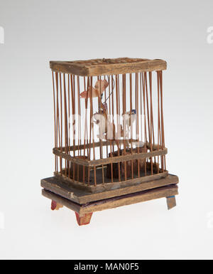 Squeaker Spielzeug mit einem kleinen Vogel in einem Käfig mit einem faltenbalg Krachmacher thront. Titel: Vogelkäfig Squeaker Spielzeug. zwischen 1875 und 1900. Stockfoto