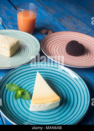 Satz von verschiedenen Kuchen auf Platten auf Blau lackiert plank Tabelle Stockfoto