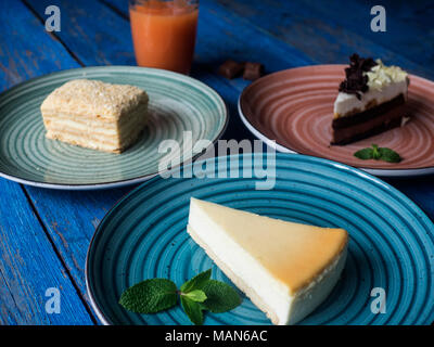 Satz von verschiedenen Kuchen auf Platten auf Blau lackiert plank Tabelle Stockfoto