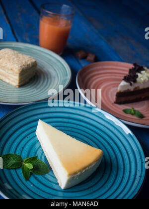 Satz von verschiedenen Kuchen auf Platten auf Blau lackiert plank Tabelle Stockfoto