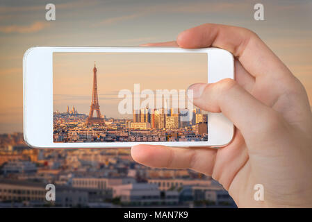 Nahaufnahme einer Hand mit Smartphone ein Bild von Paris mit dem Eiffelturm bei Sonnenuntergang, Frankreich Stockfoto