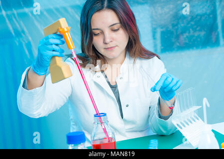 Junge Frau Techniker verwendet eine Pipette in einem chemischen Labor Stockfoto