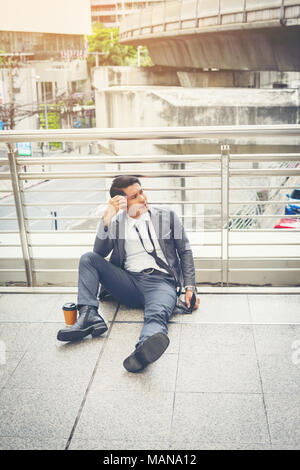 Der Mann sitzt auf dem Boden betont. Stockfoto