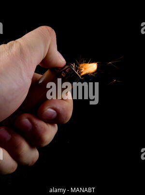 Kaukasische männliche Hand mit einem Feuerzeug, wie es Funken zu leben Stockfoto