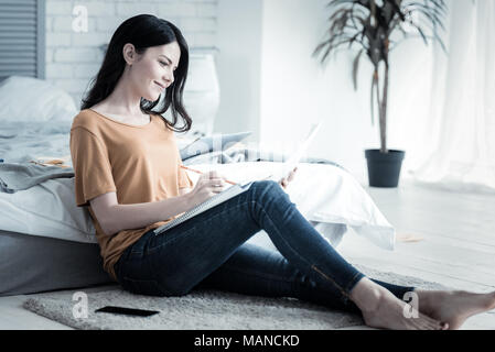 Positive Frau, die von zu Hause aus arbeiten begeistert Stockfoto