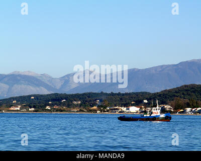 Kleines Fischerboot setzt Segel von Roda Beach, Korfu, Griechenland Stockfoto