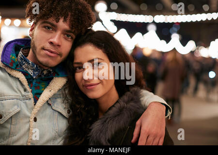 Porträt der jungen Freunde genießen Weihnachtsmarkt bei Nacht Stockfoto