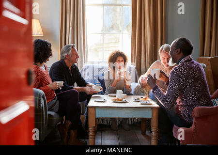 Gruppe der mittleren Alter Freunde zu treffen um den Tisch im Café Stockfoto