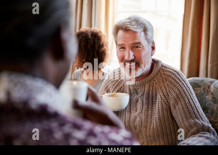 Mann im mittleren Alter Freunde zu treffen um den Tisch im Café Stockfoto