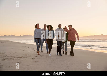 Gruppe von Freunden am Strand entlang Winter zusammen gehen Stockfoto